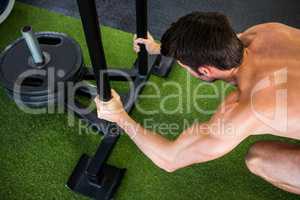 Man holding poles while exercising in gym