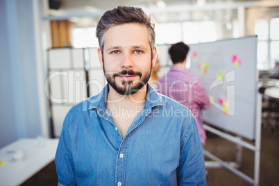 Portrait of handsome businessman standing at creative office