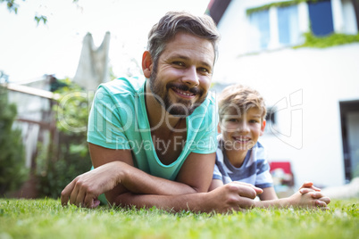 Father and son lying on grass