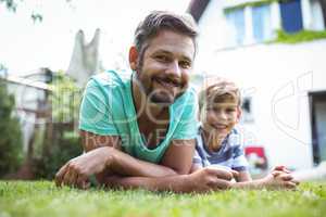 Father and son lying on grass