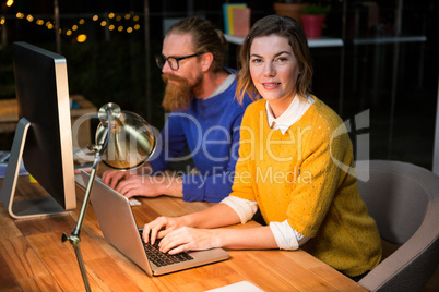 Businesswoman and colleague working on at their desk