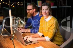 Businesswoman and colleague working on at their desk