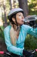 Female mountain biker drinking water