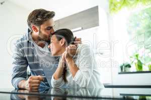 Man kissing on woman forehead