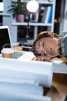 Businesswoman sleeping while working in office