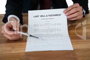 Mid section of businessman showing last will and testament form