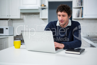 Man using laptop in the kitchen