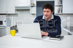 Man using laptop in the kitchen