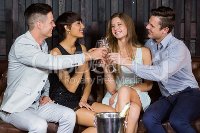 Two smiling couple toasting glasses of champagne