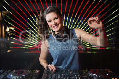 Pretty female DJ playing music