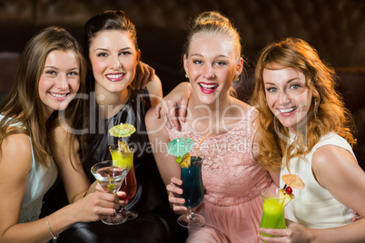 Female friends holding glasses of cocktail in bar