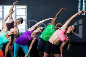 Athletes bending while exercising in gym