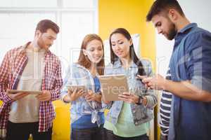 Businesswoman showing digital tablet with colleagues