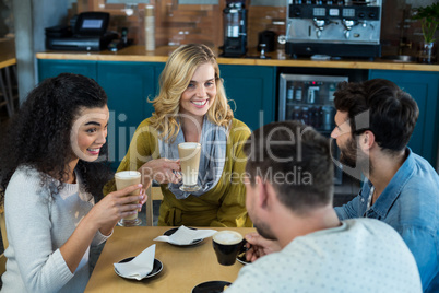 Smiling friends having a cup of coffee and cold coffee in cafÃ?Â©