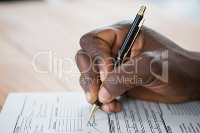 Hands of a man signing document