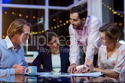 Businesspeople discussing on documents in office Businesspeople discussing on documents in office