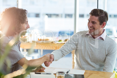 Male friends shaking hands in cafÃ?Â©