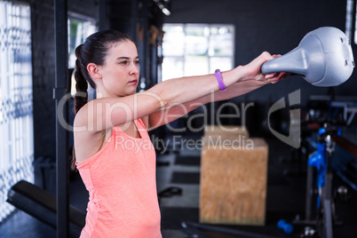 Female athlete holding kettlebell in gym