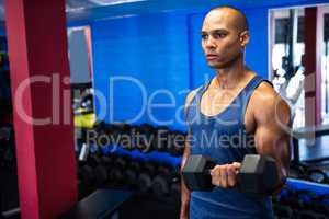 Determined man exercising with dumbbells