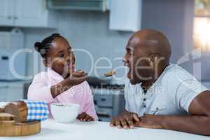 Daughter feeding breakfast to father