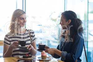 Woman interacting while having coffee in cafÃ?Â©