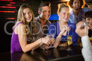 Group of friends having glass of cocktail at bar counter