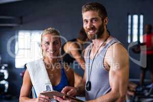 Portrait of smiling fitness instructor with woman in gym