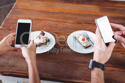 Hands taking photograph of dessert