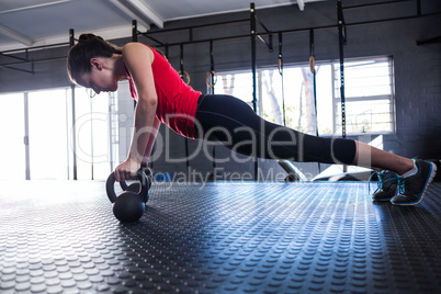 Sporty female athlete doing push-ups in gym