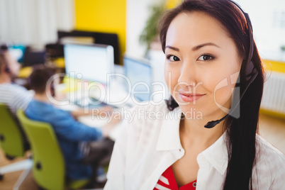 Portrait of confident executive with headphones at creative office