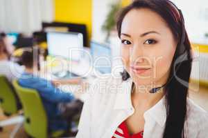 Portrait of confident executive with headphones at creative office