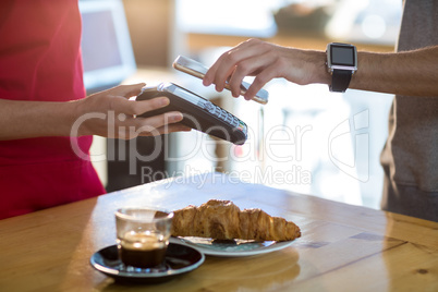 Man paying bill through smartphone using NFC technology
