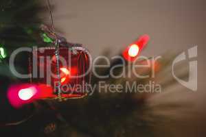 Fairy light and small gift box hanging on christmas tree