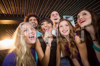 Group of friends singing song together in bar