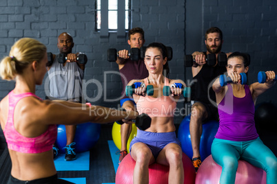 Athletes exercising with trainer in gym