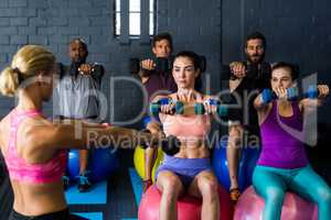 Athletes exercising with trainer in gym