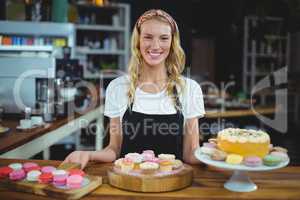 Portrait of smiling waitress standing with dessert