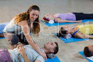 Yoga instructor helping student with a correct pose