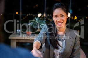 Businesswoman shaking hands with colleague