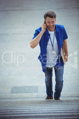 Handsome man walking on stairs while talking on mobile phone