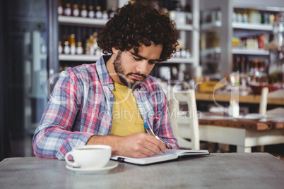 Man writing on a diary