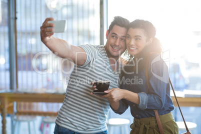 Young couple taking selfie in cafÃ?Â©