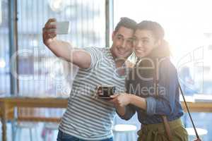 Young couple taking selfie in cafÃ?Â©