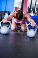 Female athlete with kettlebells in gym