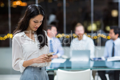 Businesswoman text messaging on mobile phone