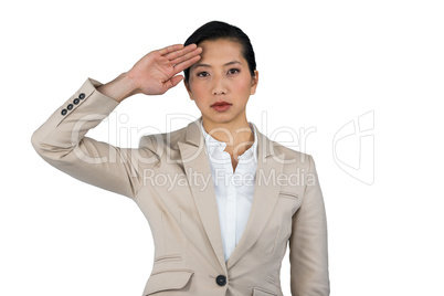 Businesswoman saluting against white background