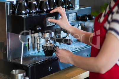 Waitress making cup of coffee in cafÃ?Â©