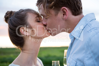 Affectionate couple kissing in field