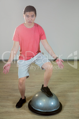 Man exercising on bosuball