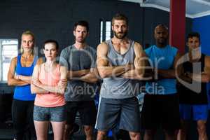 Portrait of serious friends with arms crossed in gym